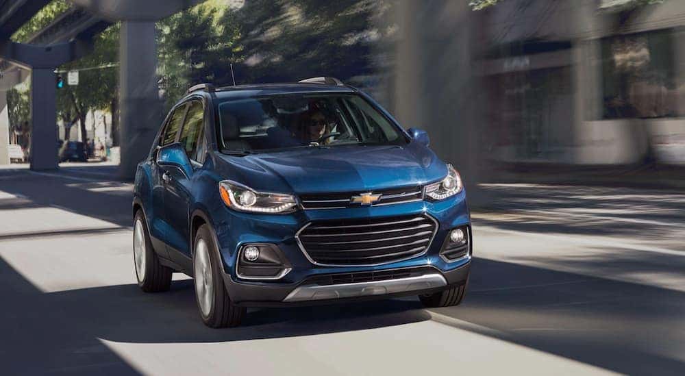 A blue 2020 Chevy Trax is shown driving on a city road.