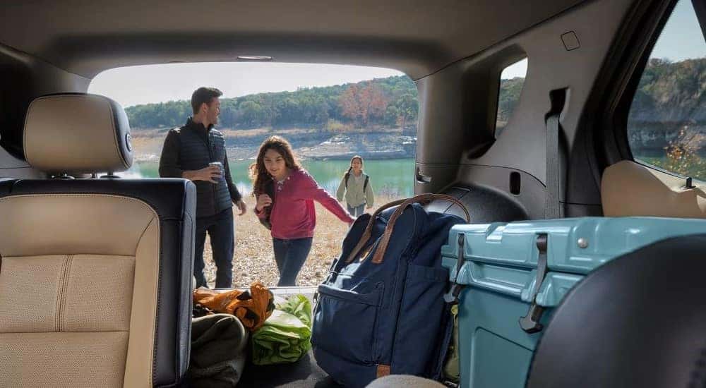 A family loading camping gear into the back of a 2024 Chevy Equinox Premier for sale near Louisville.