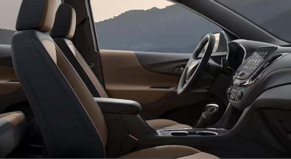 The black and brown interior and dash of a 2024 Chevy Equinox Premium is shown.