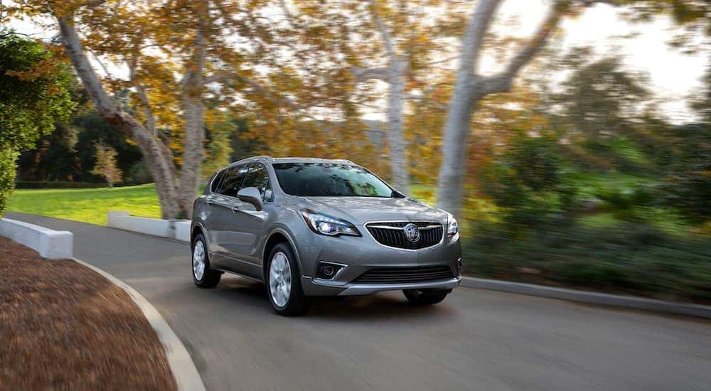 A grey 2021 Buick Envision is driving down the road after leaving the Buick dealer.