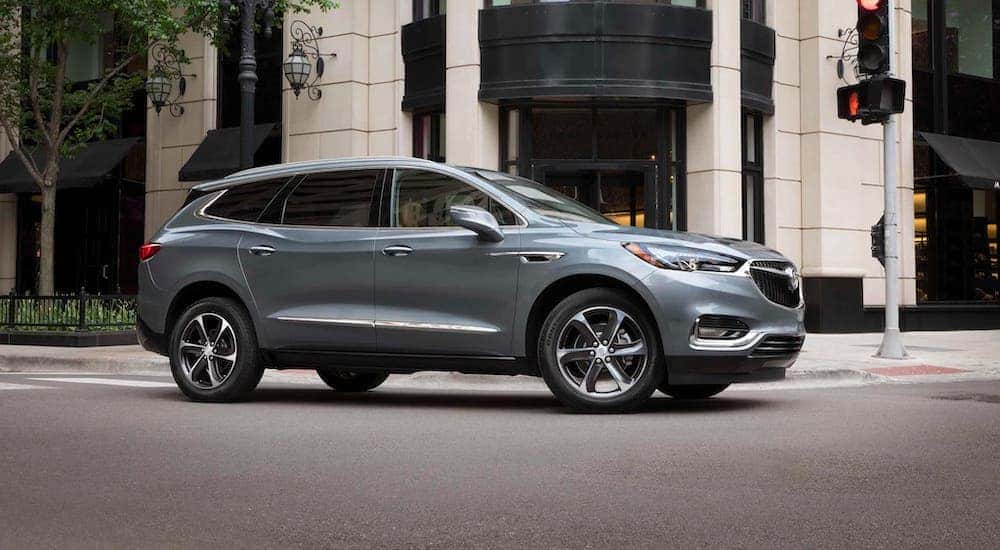 A gray 2021 Buick Enclave is driving on a city street after leaving a Buick dealer near Lexington, KY.