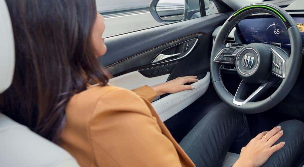 A person is shown using Super Cruise feature in a 2024 Buick Envision Avenir.