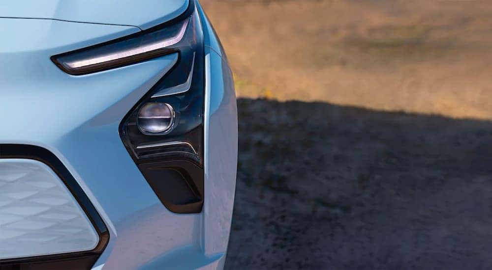 A close up shows the headlight and foglight on a silver 2022 Chevy Bolt EV.