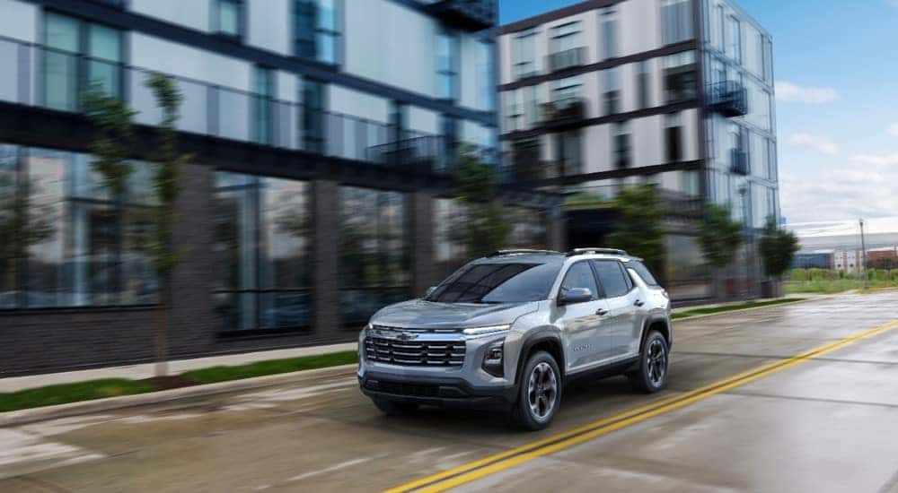 A silver 2025 Chevy Equinox LT driving on a city street.