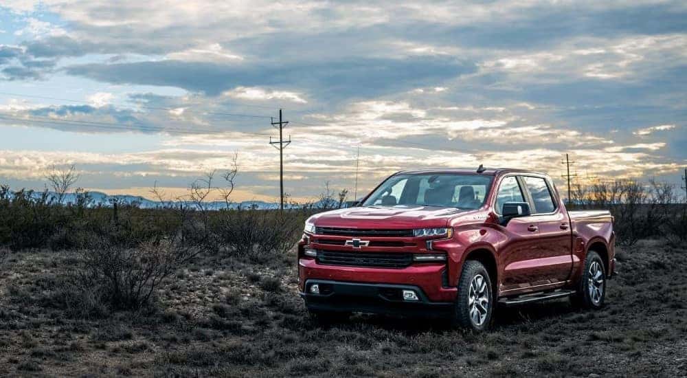 A red 2024 Chevy Silverado 1500 RST parked off-road.