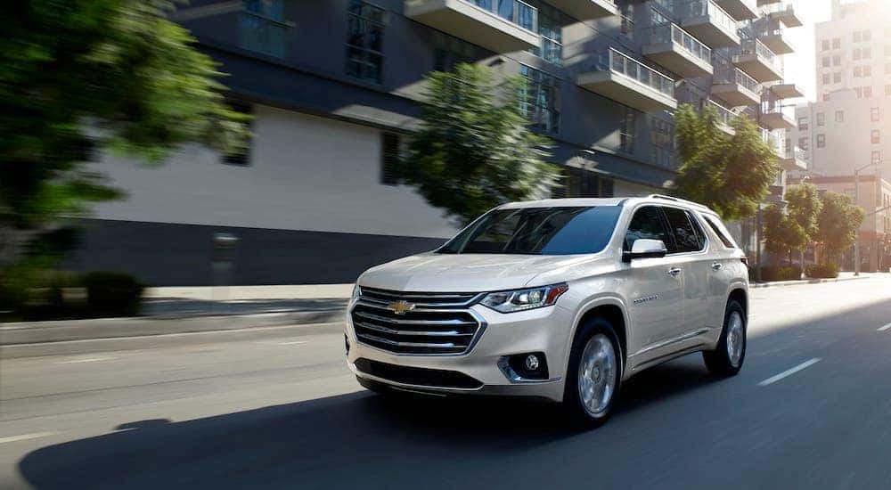 A white 2020 Chevy Traverse is driving through a city street after leaving a Lexington used car dealer.