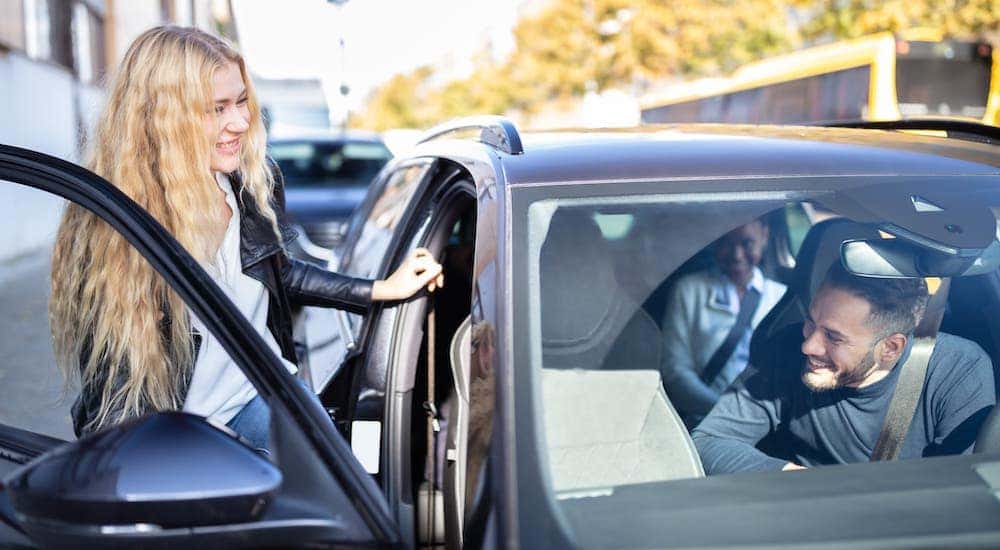 A woman is climbing into a car to carpool.