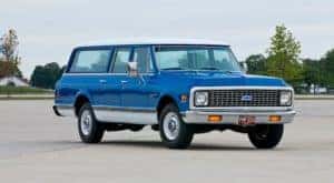 A blue and white 1972 Chevy Suburban is shown in an empty lot after leaving a Kentucky used car lot.