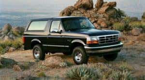 A black 1994 Ford Bronco XLT is shown parked with rocks in the background.