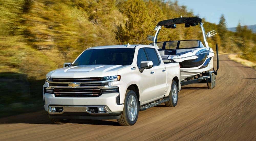 A white 2020 Chevy Silverado is towing a boat.