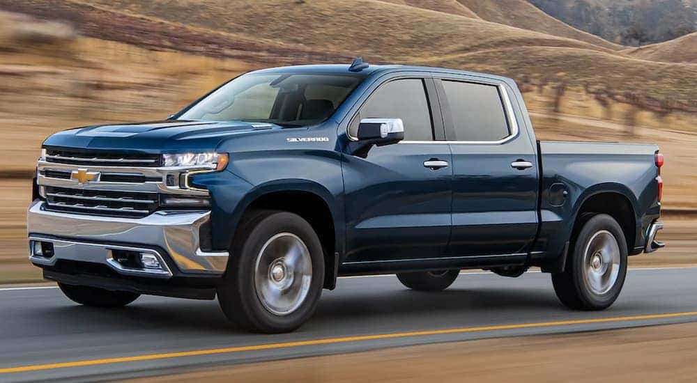 A blue 2021 Chevy Silverado 1500 is driving to a Lexington Silverado dealer.