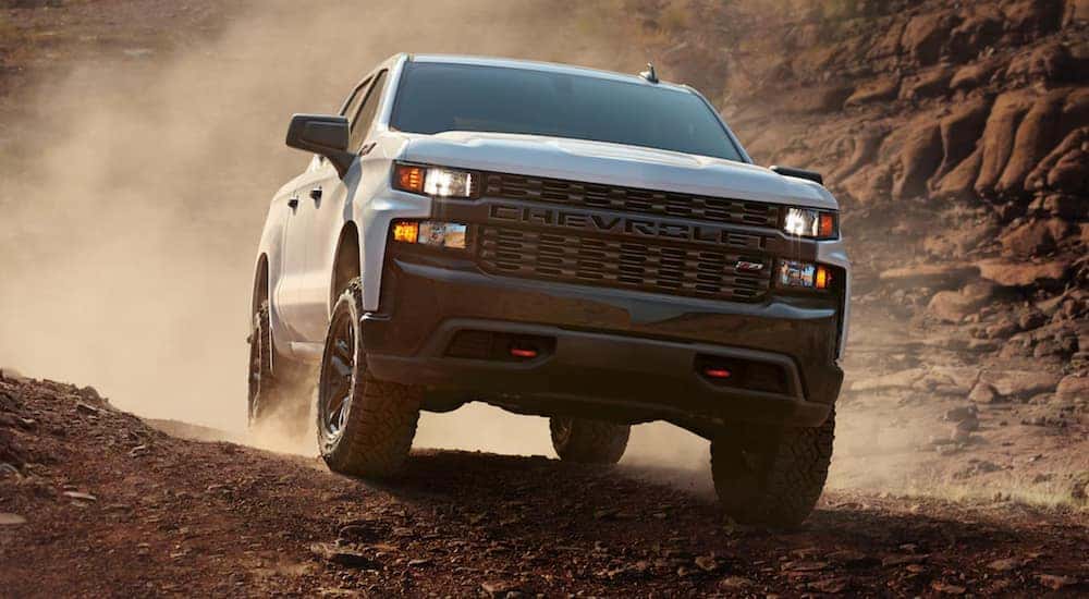 A white 2021 Chevy Silverado is off-roading in the desert after leaving a Lexington Silverado dealer.