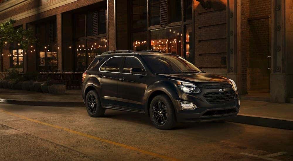 A black 2017 Chvey Equinox is parked on a city street at night.