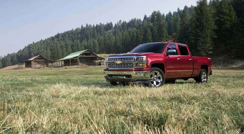 A red 2017 Chevy Silverado LTZ is parked in front of a cabin after the owner bought a used Chevy 1500 for sale.