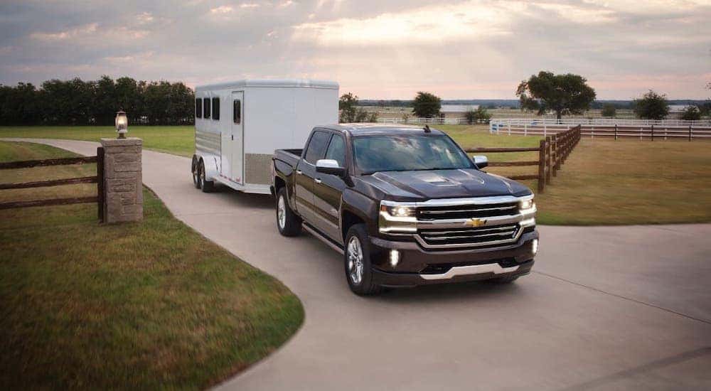 A black 2018 Chevy Silverado 1500 High Country is towing an enclosed trailer.