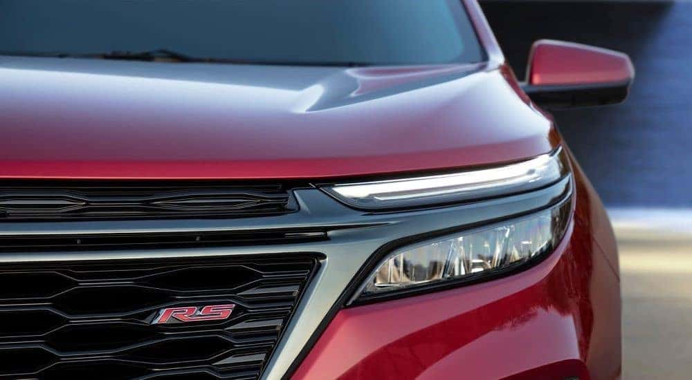A close up shows the driver side headlight on a red 2022 Chevy Equinox RS.
