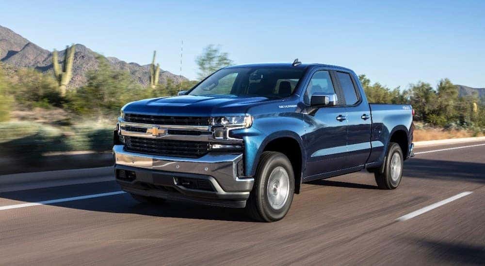 A blue 2019 Chevy Silverado 1500 is driving down a highway.