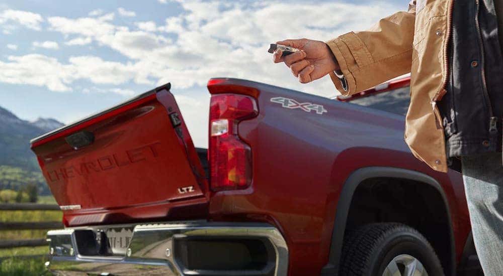 A man uses his key to open the lift-gate of his 2020 Chevy Silverado HD Truck