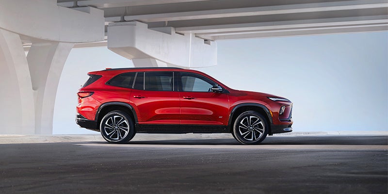 Red Buick Enclave parked in a garage at a high level with clear blue sky